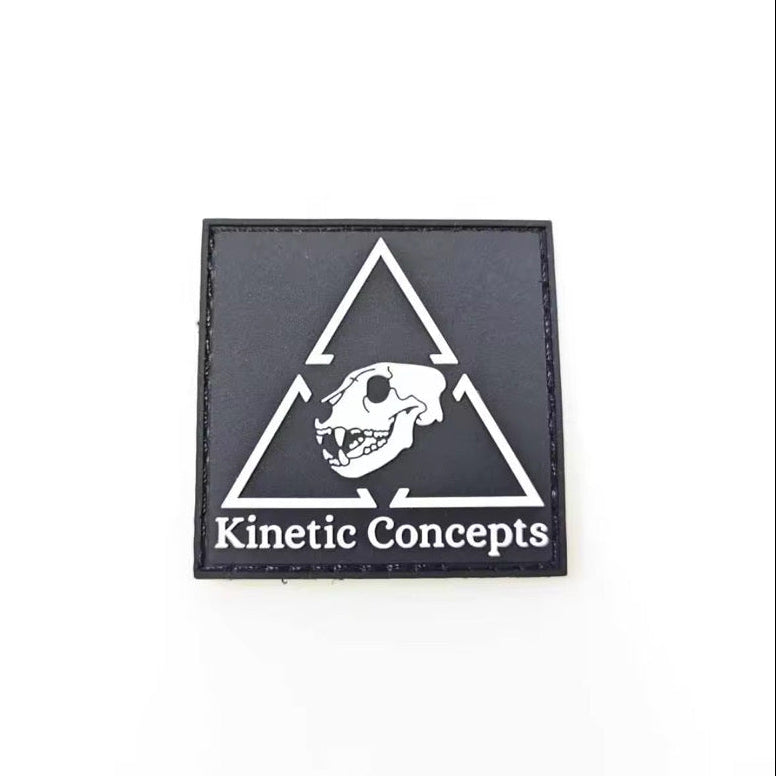 Black square patch with white triangle and skull design, featuring 'Kinetic Concepts' text, on a white background.
